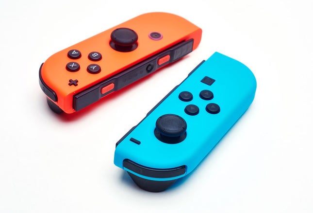 Two Nintendo Switch Joy-Con controllers rest on a white surface.